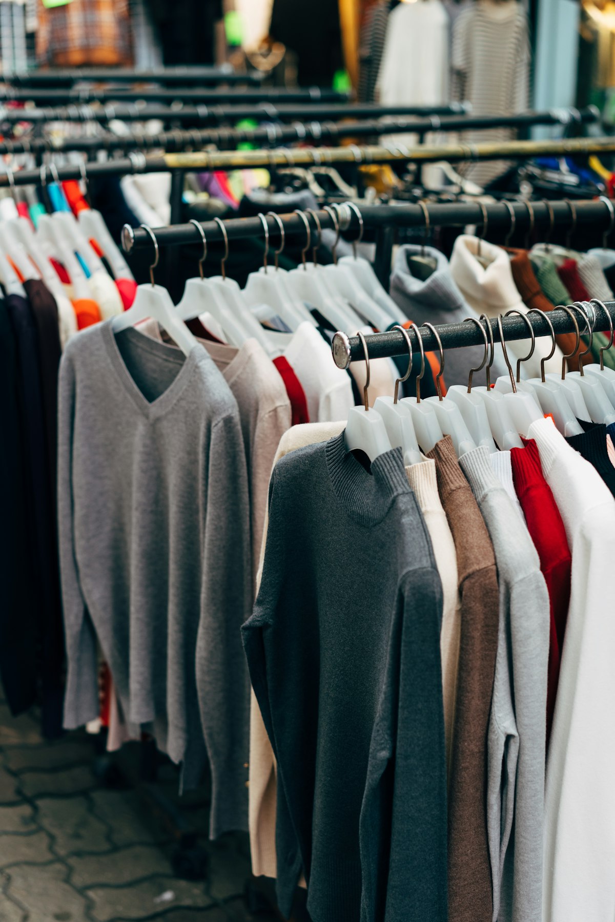 Neatly arranged sweaters on a retail rail